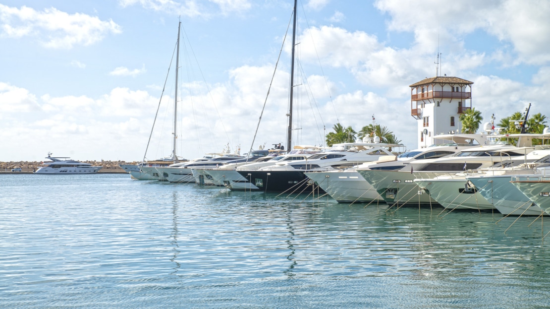 der Hafen von Portal Nous mit blauem Wasser und Motoryachten